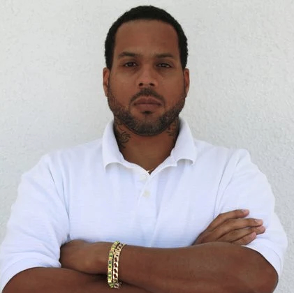 photo of an unsmiling man with arms crossed