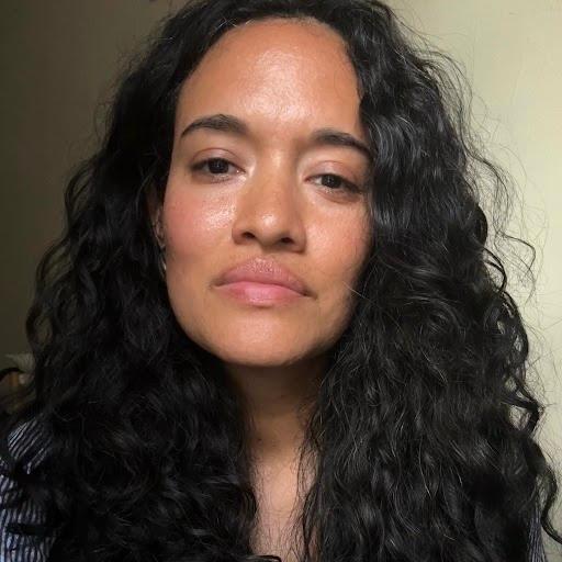 headshot of a woman with long, dark, wavy hair