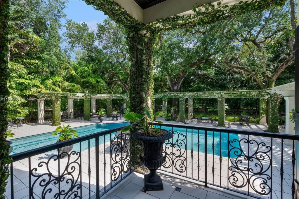 Depicted is a porch-side view of an L-shaped in a backyard oasis.
