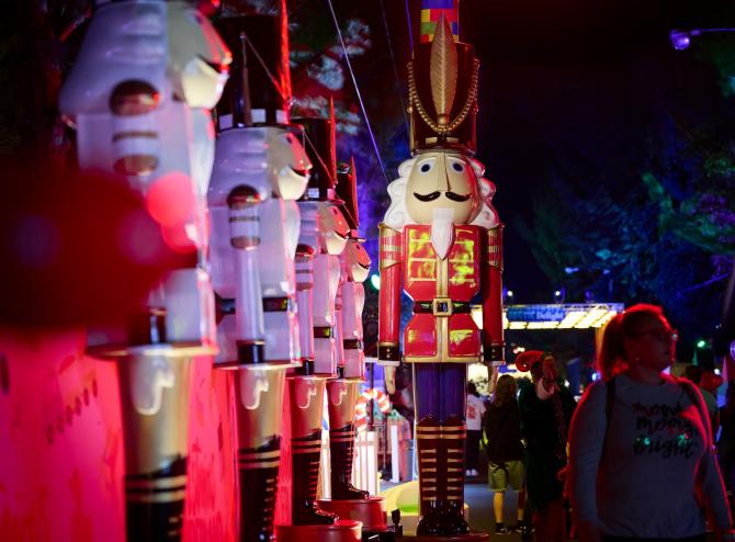 a row of nutcrackers illuminated in Christmas lighting at a holiday park