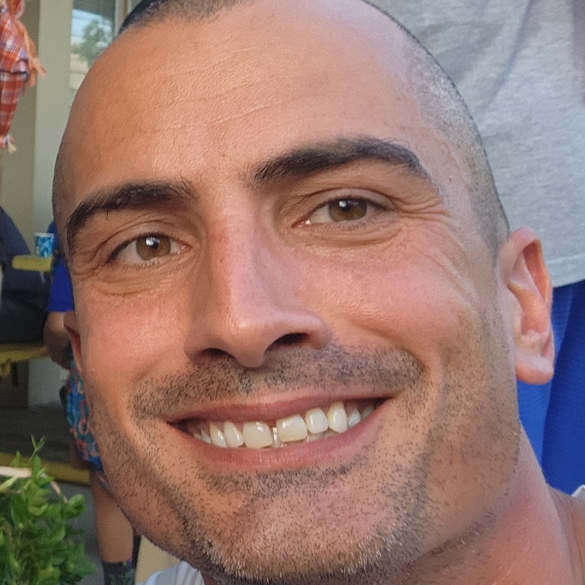 photo of a smiling young man with close-cropped hair and 5-o'clock shadow