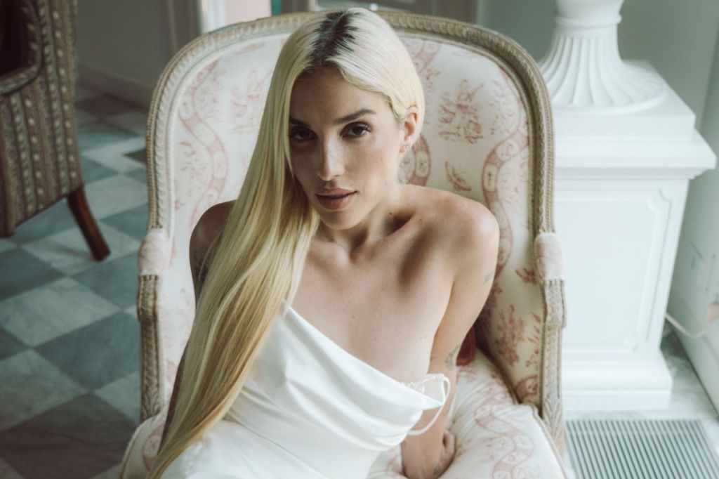 photo of a blonde woman sitting on a couch posing for the camera