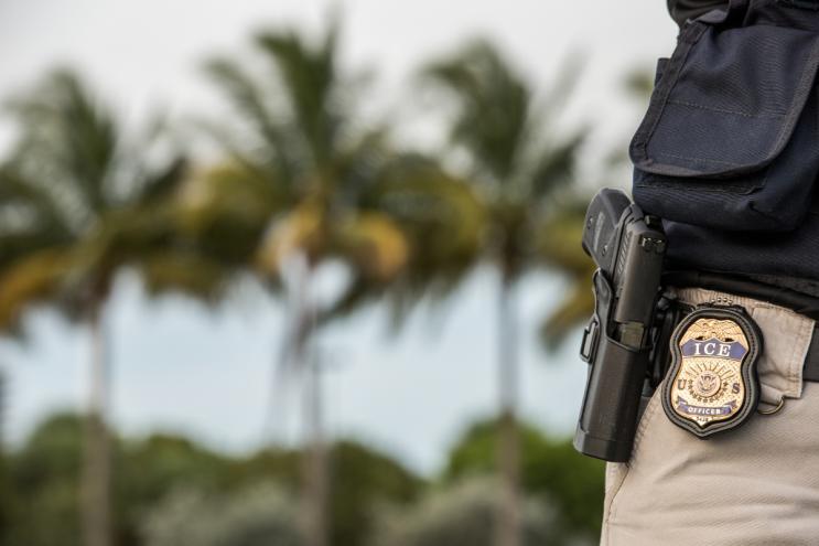 An officer wearing an ICE badge.