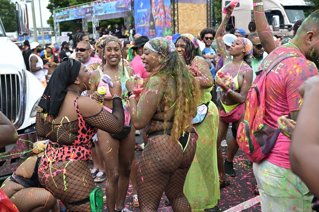 dozens of festivalgoers splattered in paint dance together