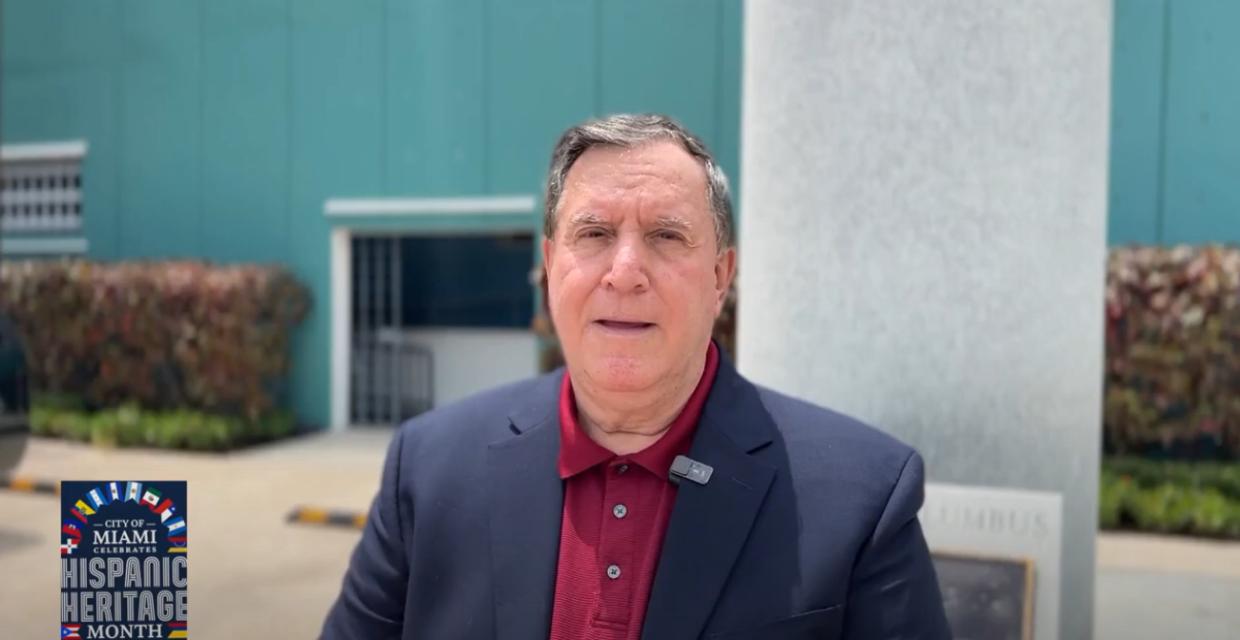 Joe Carollo looks into camera wearing navy sport jacket and red polo