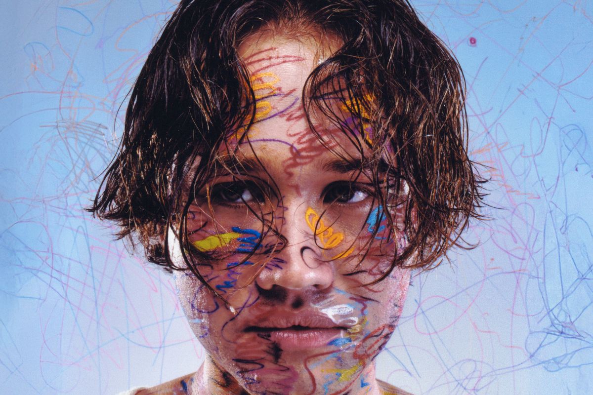 picture of a man looking at a camera covered in paint.