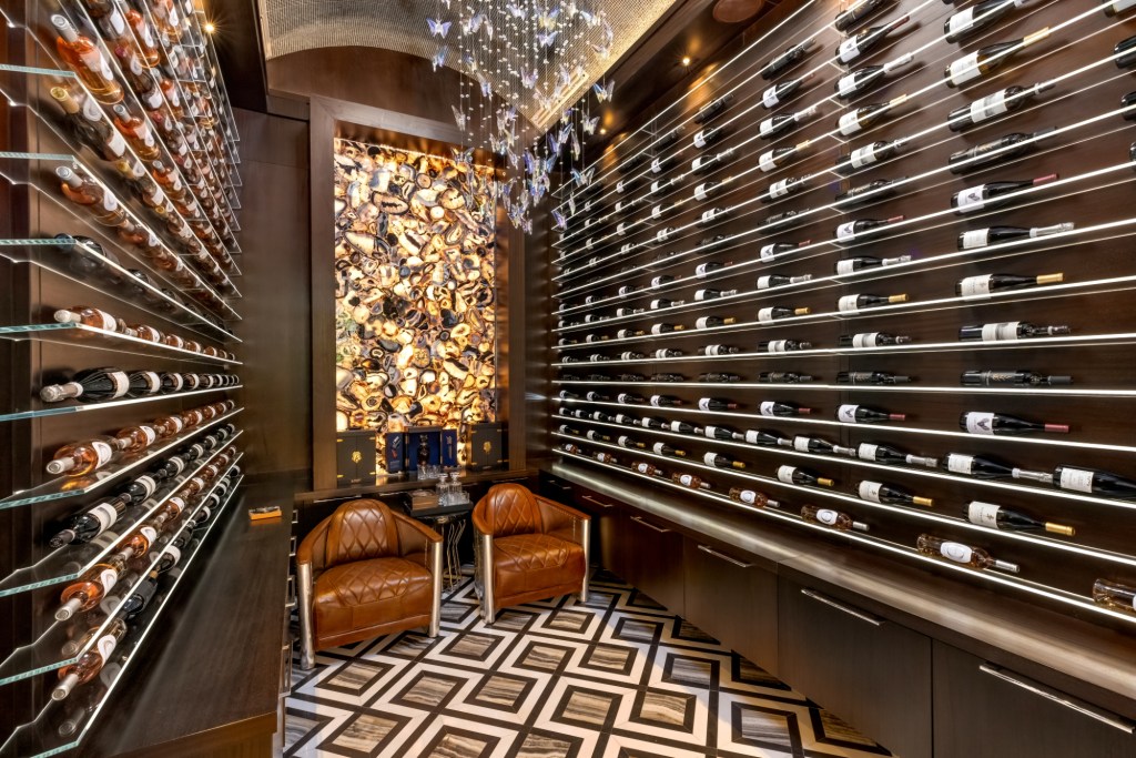Wine room with winte along the walls with two chairs in the middle