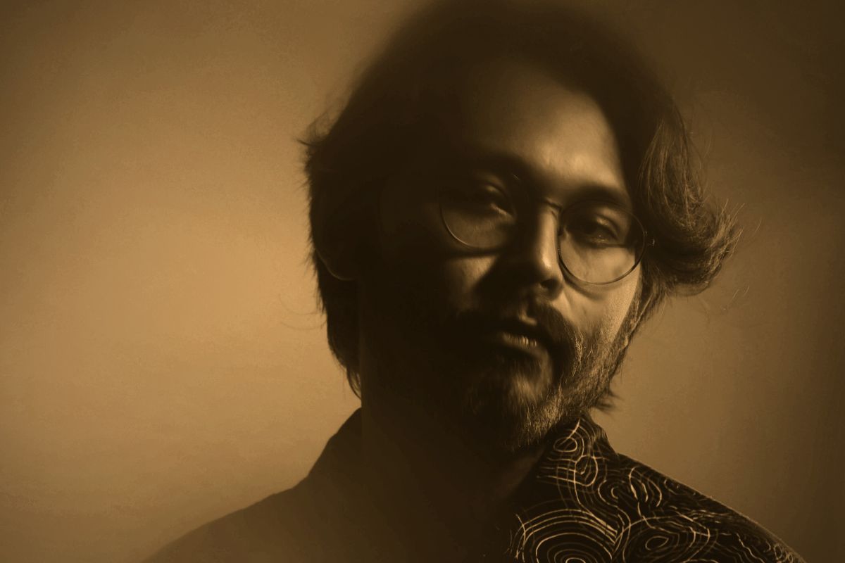 sepia portrait photo of a man wearing glasses.