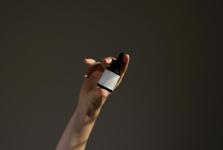A hand holding a serum.