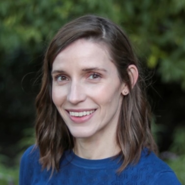 headshot of a smiling, dark-haired woman