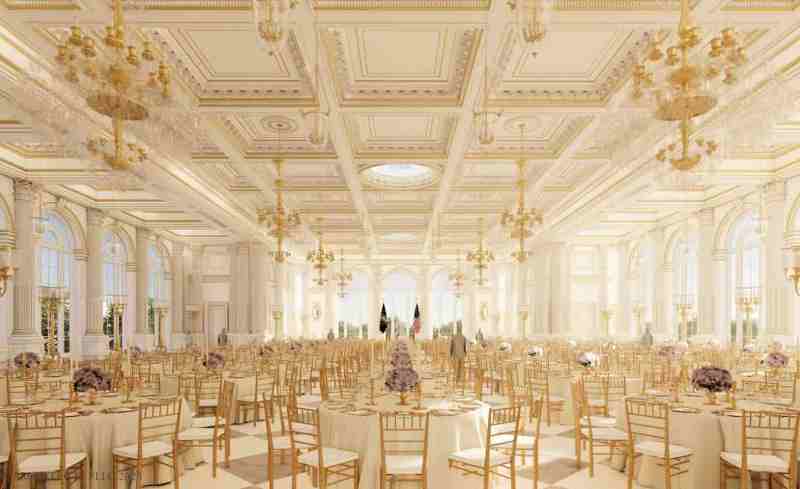 dozens of tables sit in an white-and-gold ballroom with ornate chandeliers hanging above