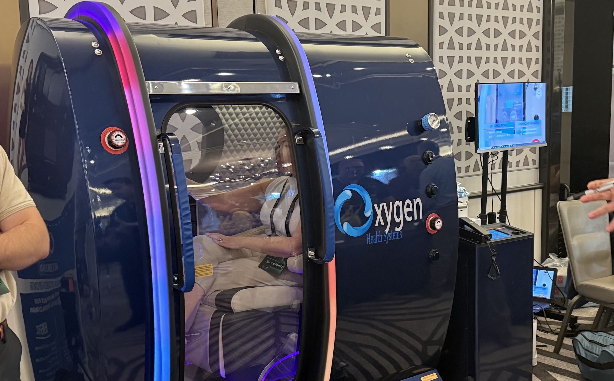 photo of a person sitting inside a blue hyperbaric chamber