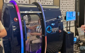 photo of a person sitting inside a blue hyperbaric chamber