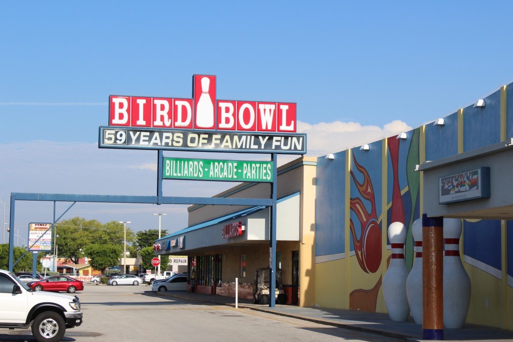 Photo of the front facade of a bowling alley in a plaza. The sign at the front reads "Bird Bowl, 59 Years of Family Fun, Billiards - Arcade - Parties