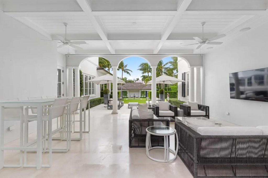several sitting areas rest in an all-white backyard patio