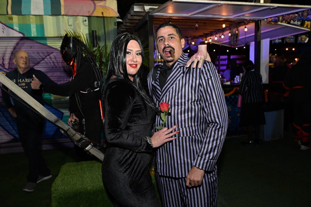 photo of two people dressed as Gomez and Morticia Addams for Halloween