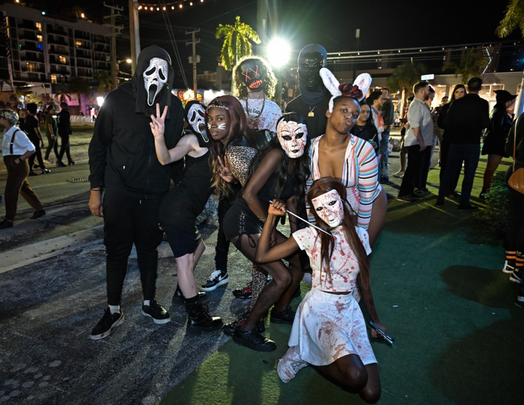 photo of a group of friends posing in Halloween costumes on the street