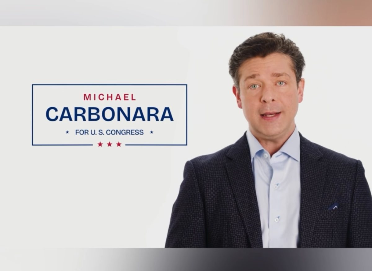 A photo of a white man with brown hair speaking for a campaign ad.