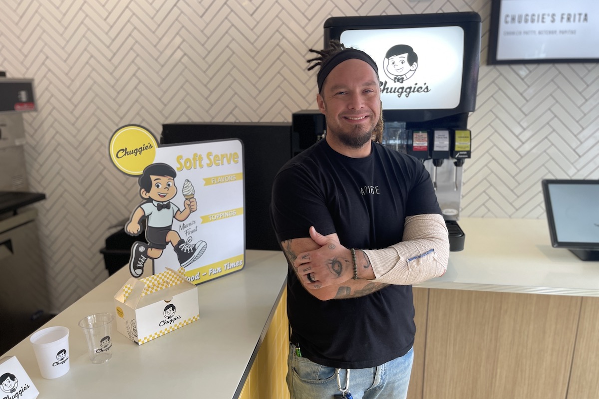 man poses in black shirt at a diner