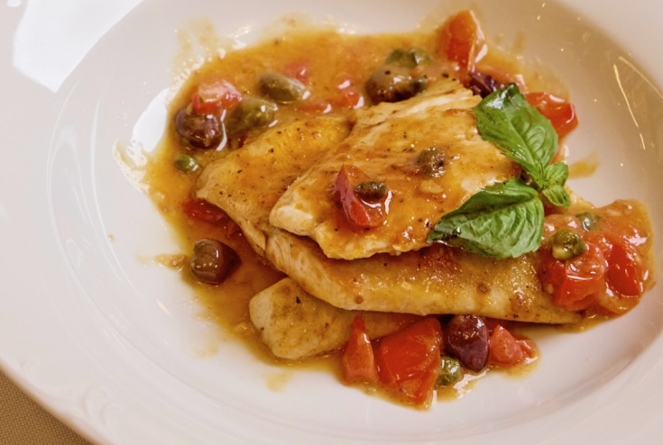 a fish or meat dish on a white plate