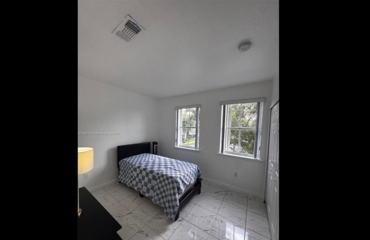 A photo of a small bedroom with a bed.
