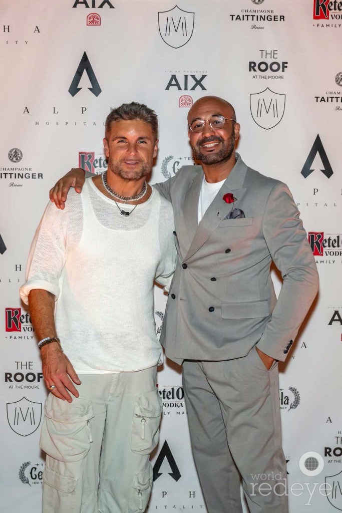 photo of two men posing together in front of a step-and-repeat