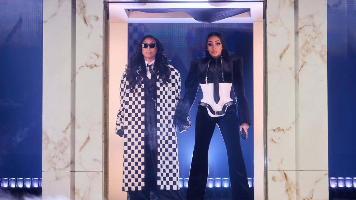 Two woman standing under a door frame holding hands