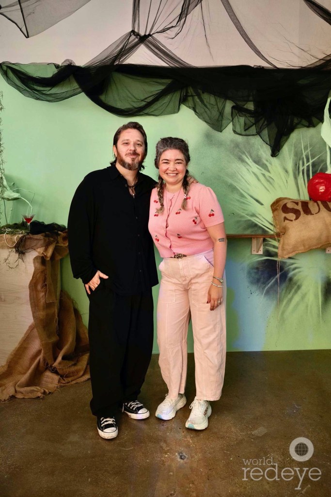 photo of two people posing in front of an art installation