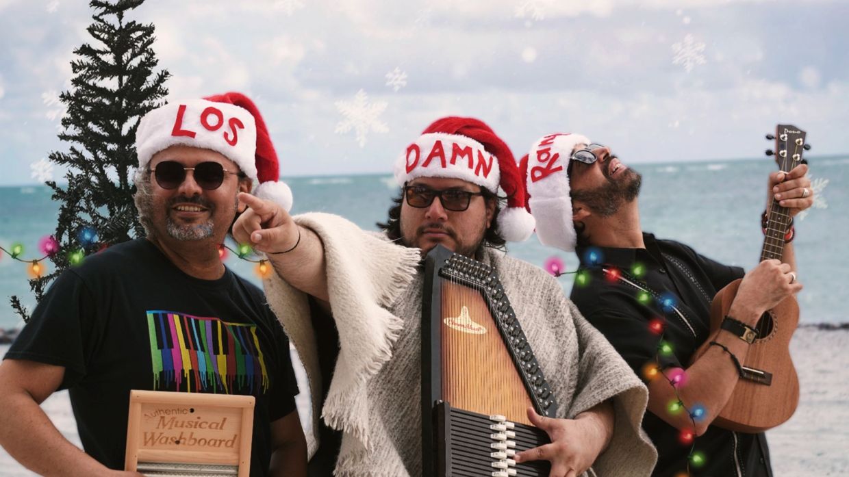 Photo of men wearing christmas hats at the beach.