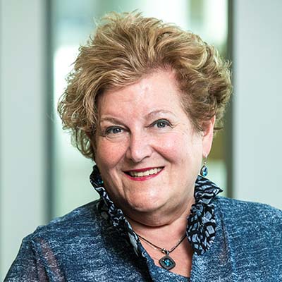 headshot of a smiling woman with a short updo