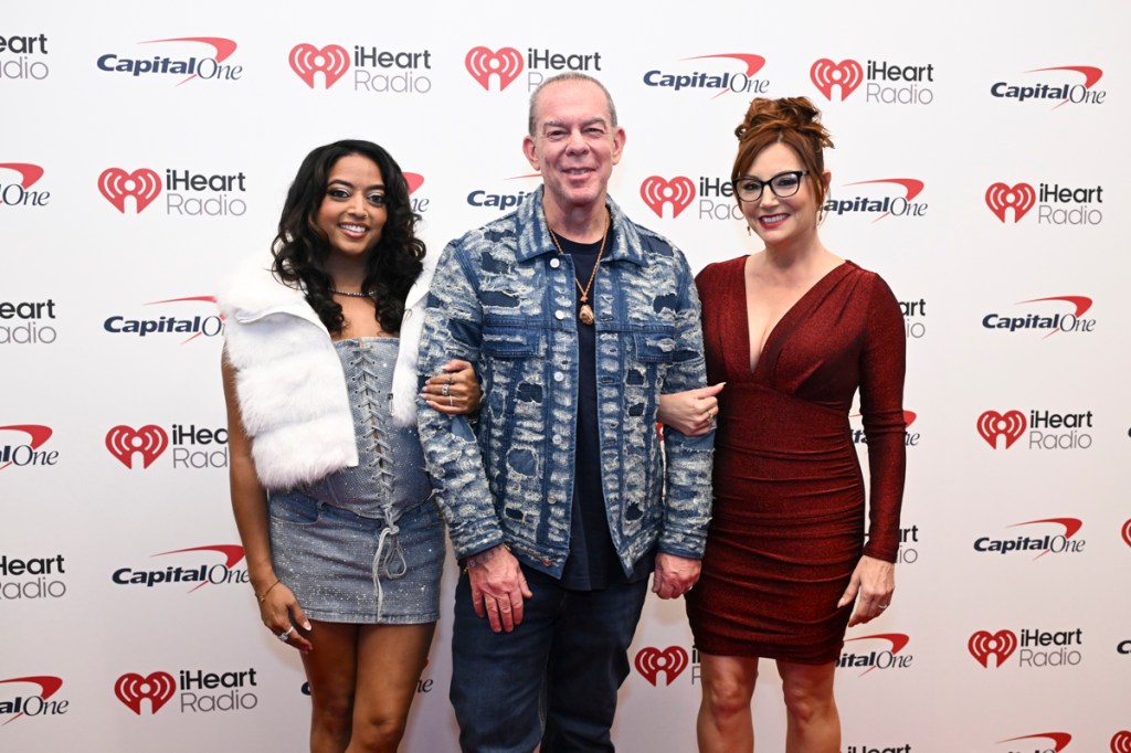 Photo of a man and two women posing for the camera . 