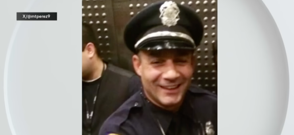 A Miami Police officer wearing his official cap smiles for the camera