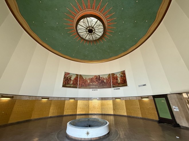 photo of the rotunda of a building with a green ceiling and golden P.O. boxes on the back wall
