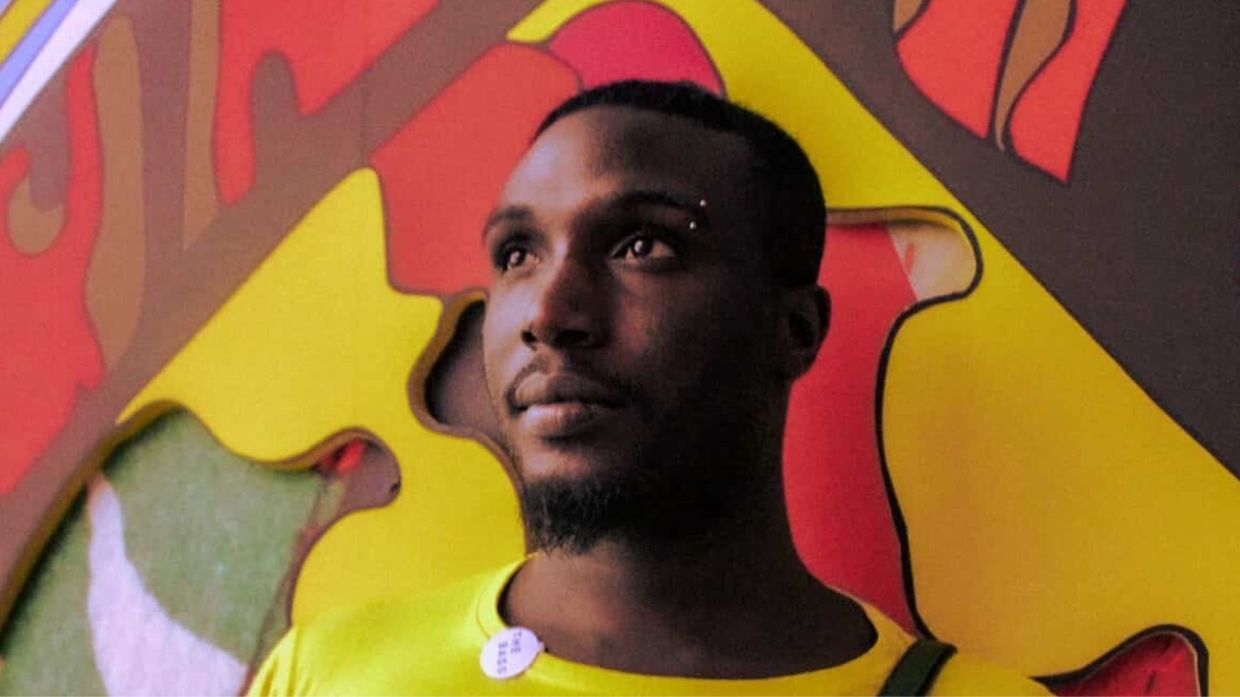 Photo of a man standing by a colorful mural