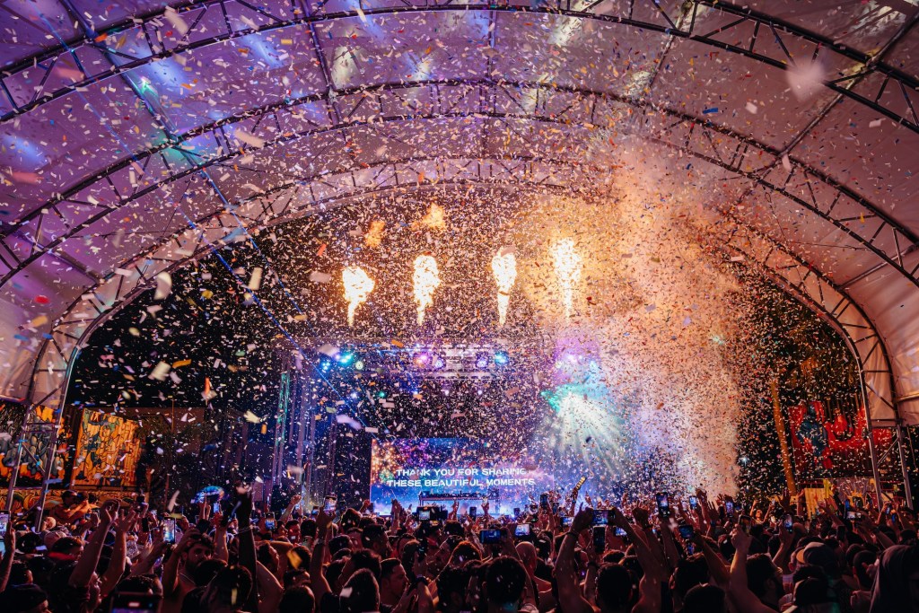 Photo of a crowd raising their hands during a festival. 