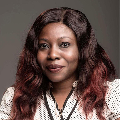 headshot of a smiling woman with wavy auburn