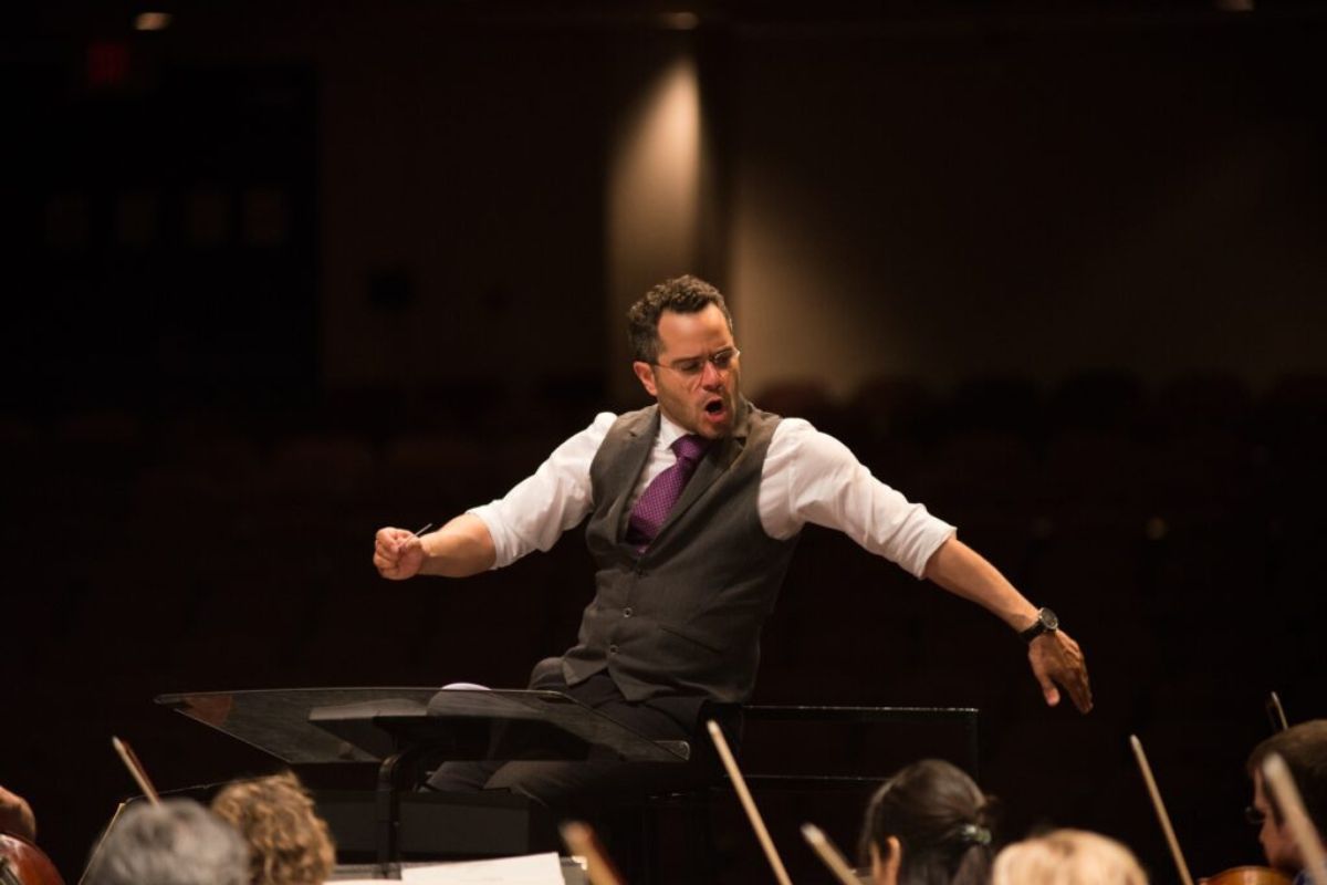 A conductor in front of an orchestra