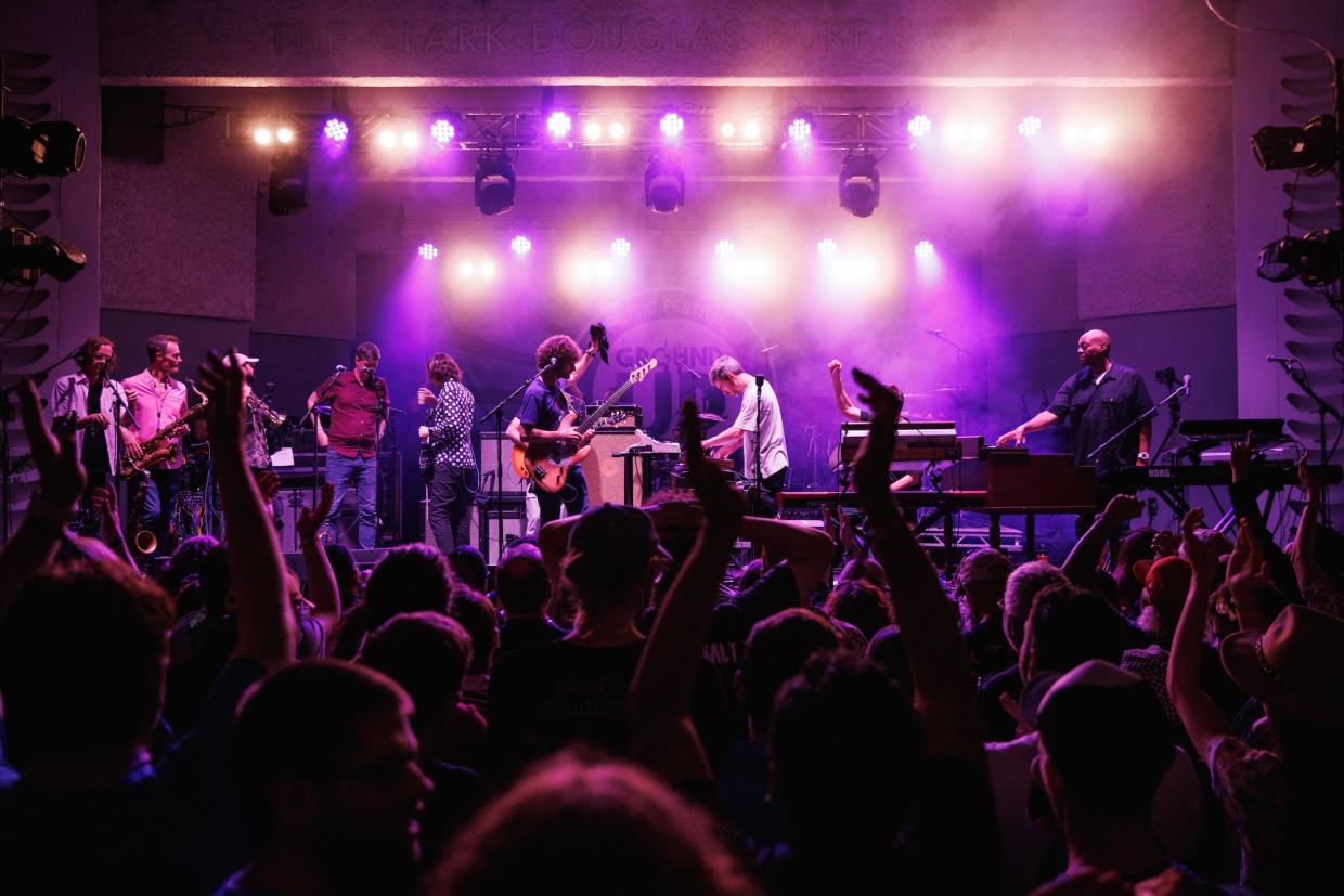 A band on stage under purple lights