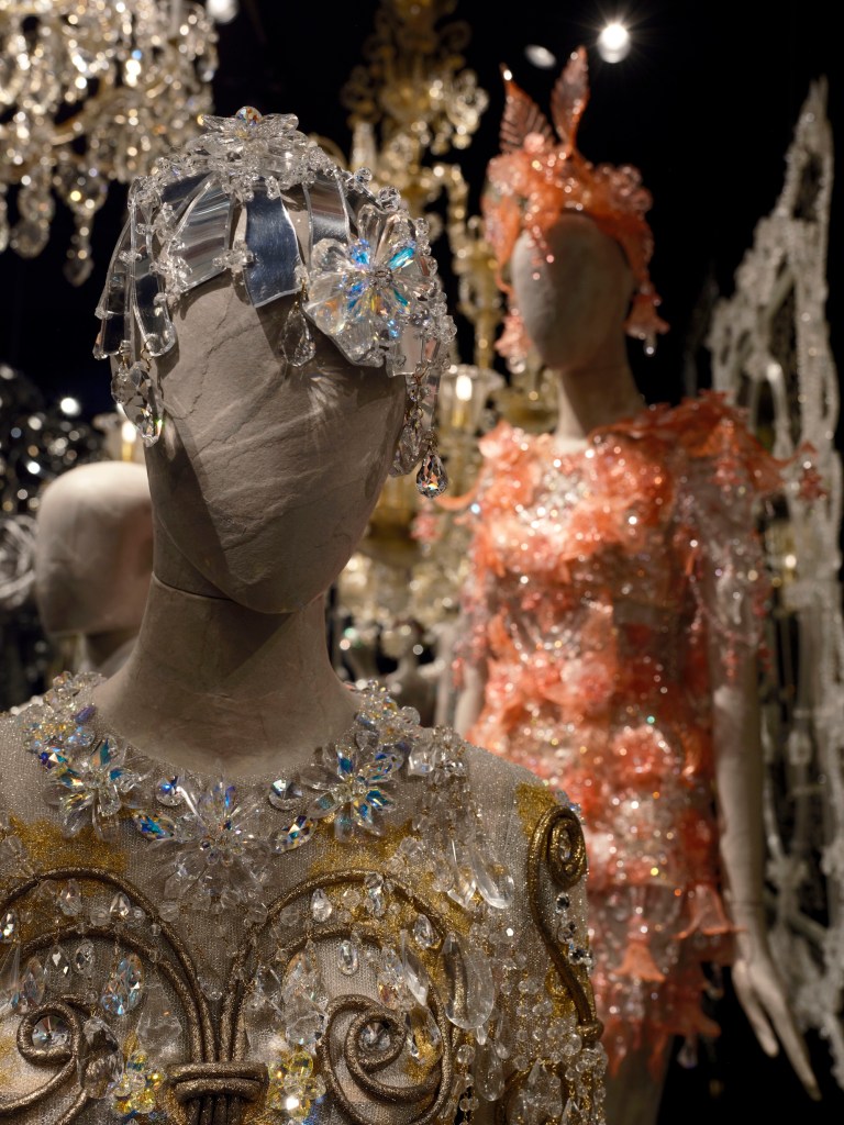 close-up photo of two ornate outfits on two mannequins