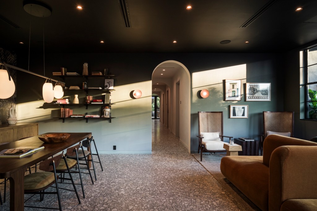 photo of a hotel lobby with couches, a long table, and shelves on the walls