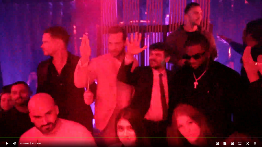 A bald man with a beard is seen on a live stream under men doing the Nazi salute.