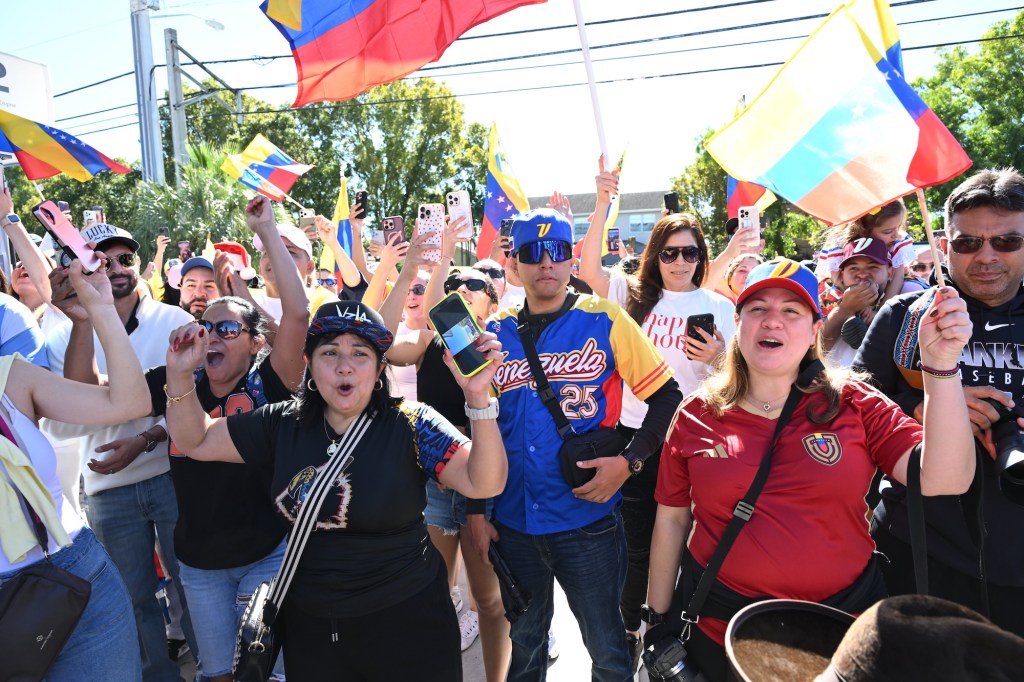 photo of protesters wearing clothes with the Venezuelan flag and waving Venezuelan flags.