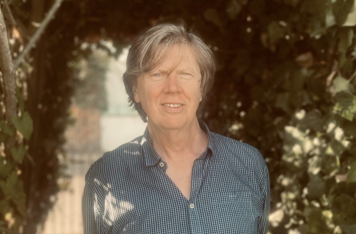 Photo of a man with grey hair looking at the camera.