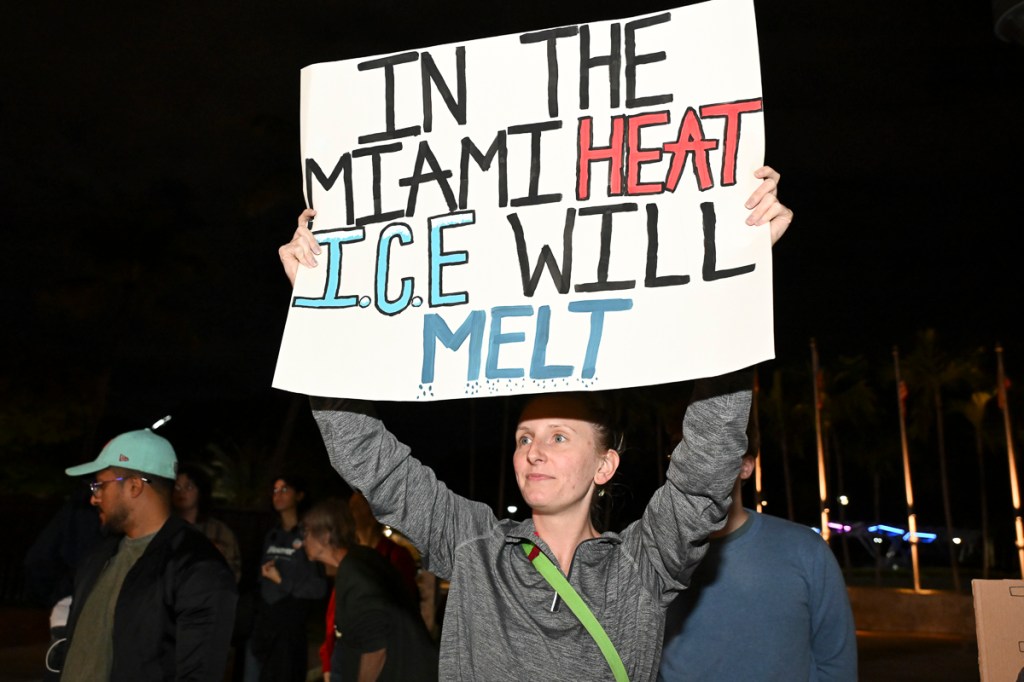 photo of a protester holding a sign reading, "in the Miami heat ICE will melt"