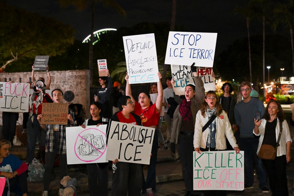 photo of protesters at a rally holding up signs in protest of ICE