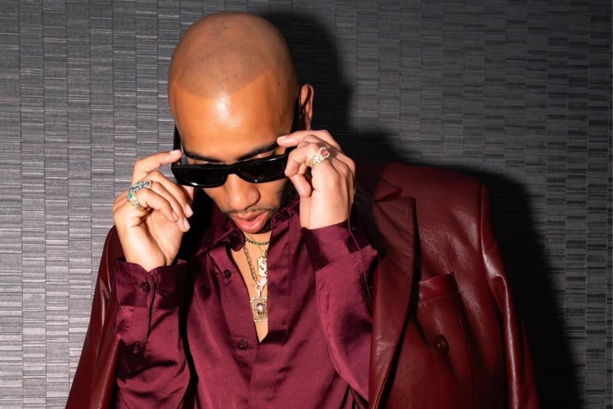 Photo of a bald man wearing a red leather suit and sunglasses