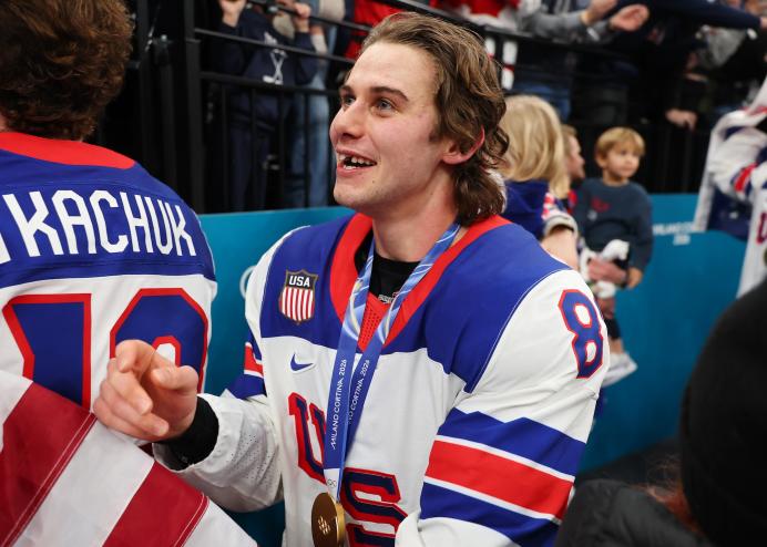 Jack Hughes wearing his gold medal smiling with his missing teeth