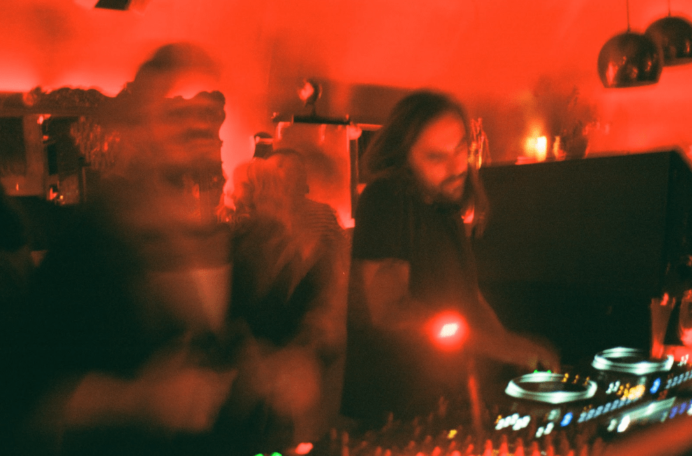 Blurred photo of two DJs under red lights