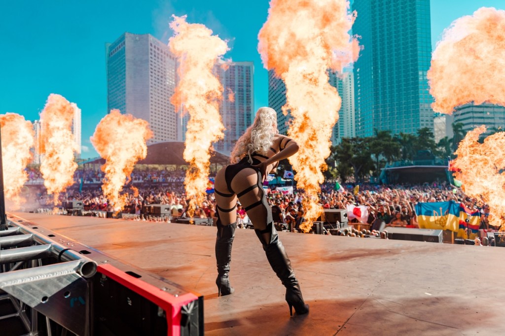 Photo of a woman dancing on stage next to fire