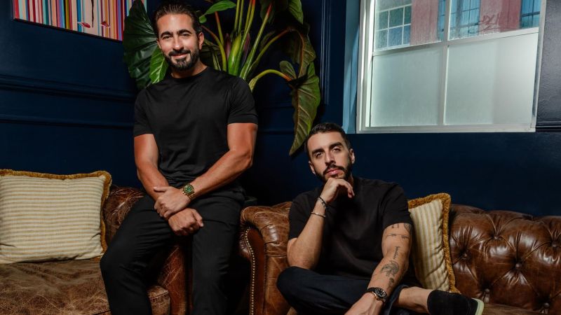 Photo of two men sitting on a leather couch